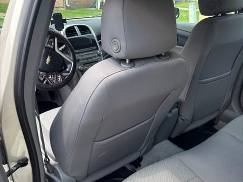 Cloth rear seats and carpet cleaned during an interior detail, photographed through the open rear door