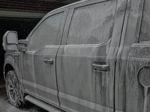 Ford F-150 covered in snow foam during an exterior hand wash