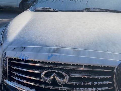 Infiniti covered in snow foam during an exterior hand wash